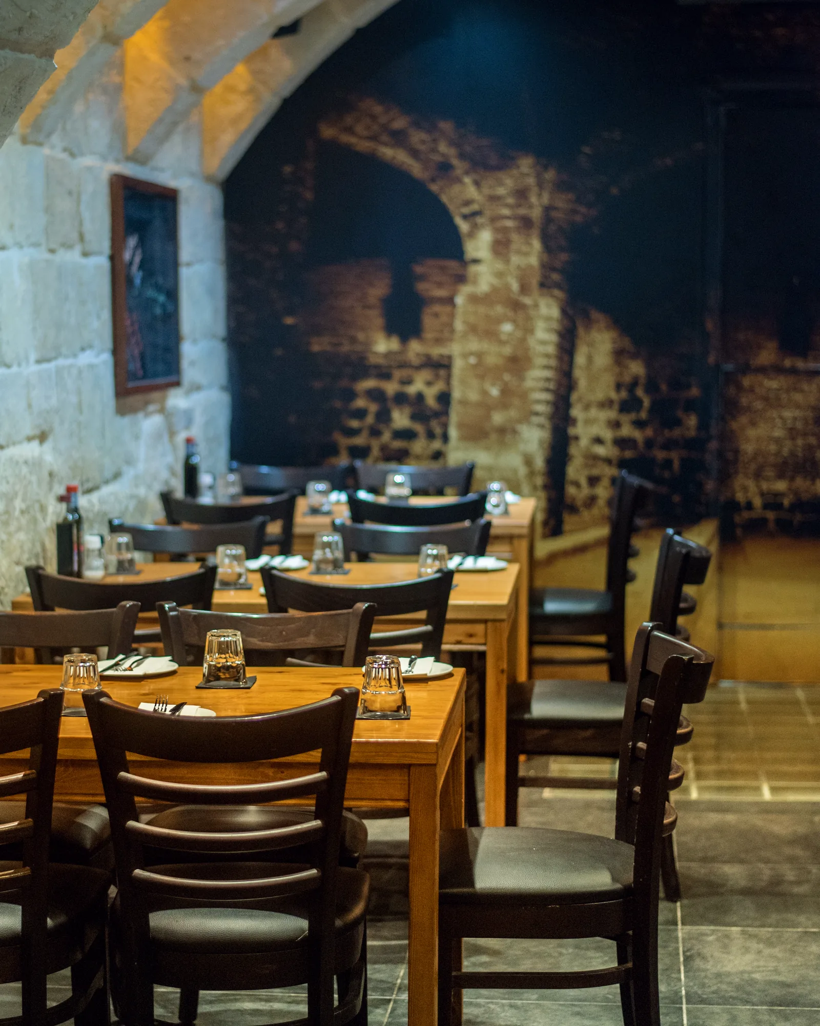 The bistro at STR·EAT, restaurant tables laid for dinner beneath a limestone barrel vault