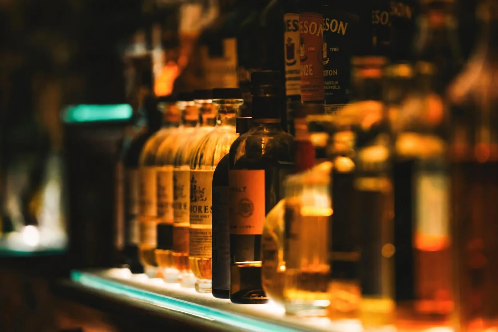 Single malts glowing on a lit shelf at STR·EAT whisky bar